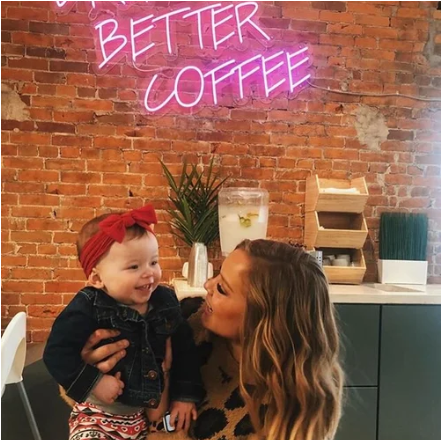 woman and baby smiling at the coffee house